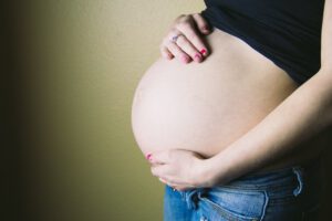 Kobieta w ciąży trzyma się za brzuch