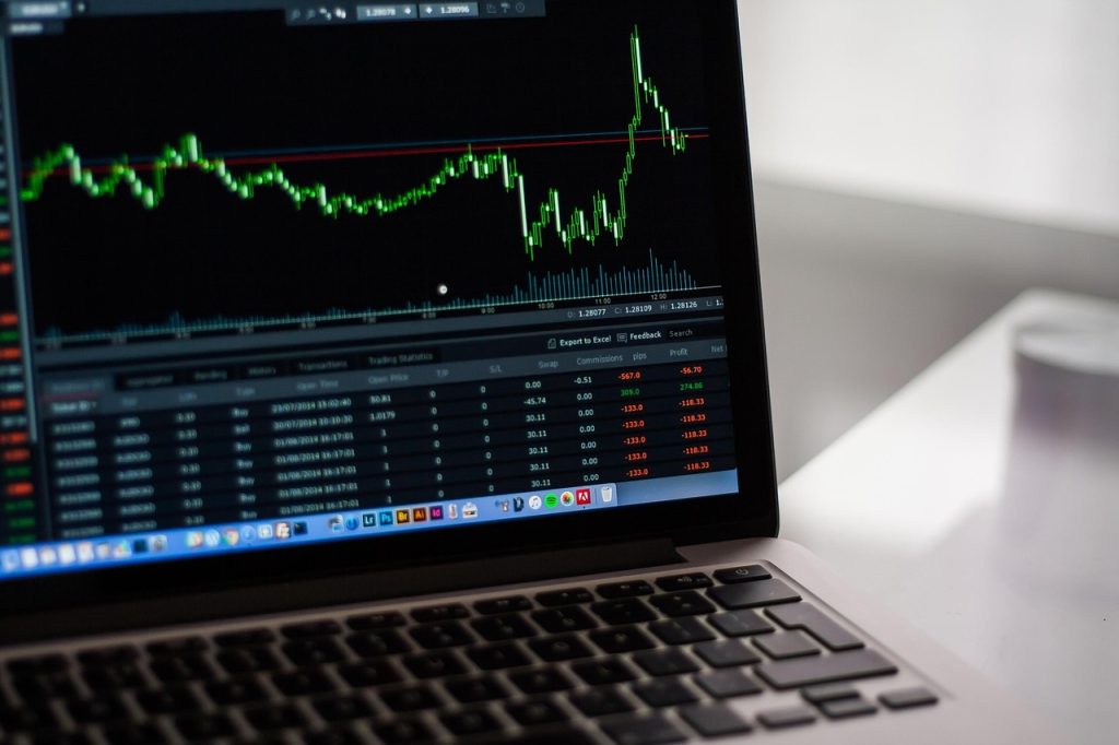 Wykres finansowy z notowaniami wyświetlony na ekranie laptopa.