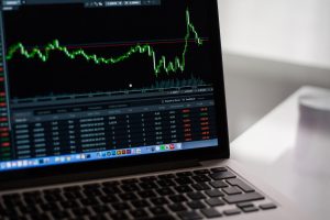 Wykres finansowy z notowaniami wyświetlony na ekranie laptopa.